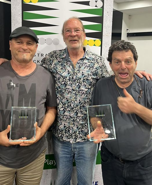 3 men, two holding trophies