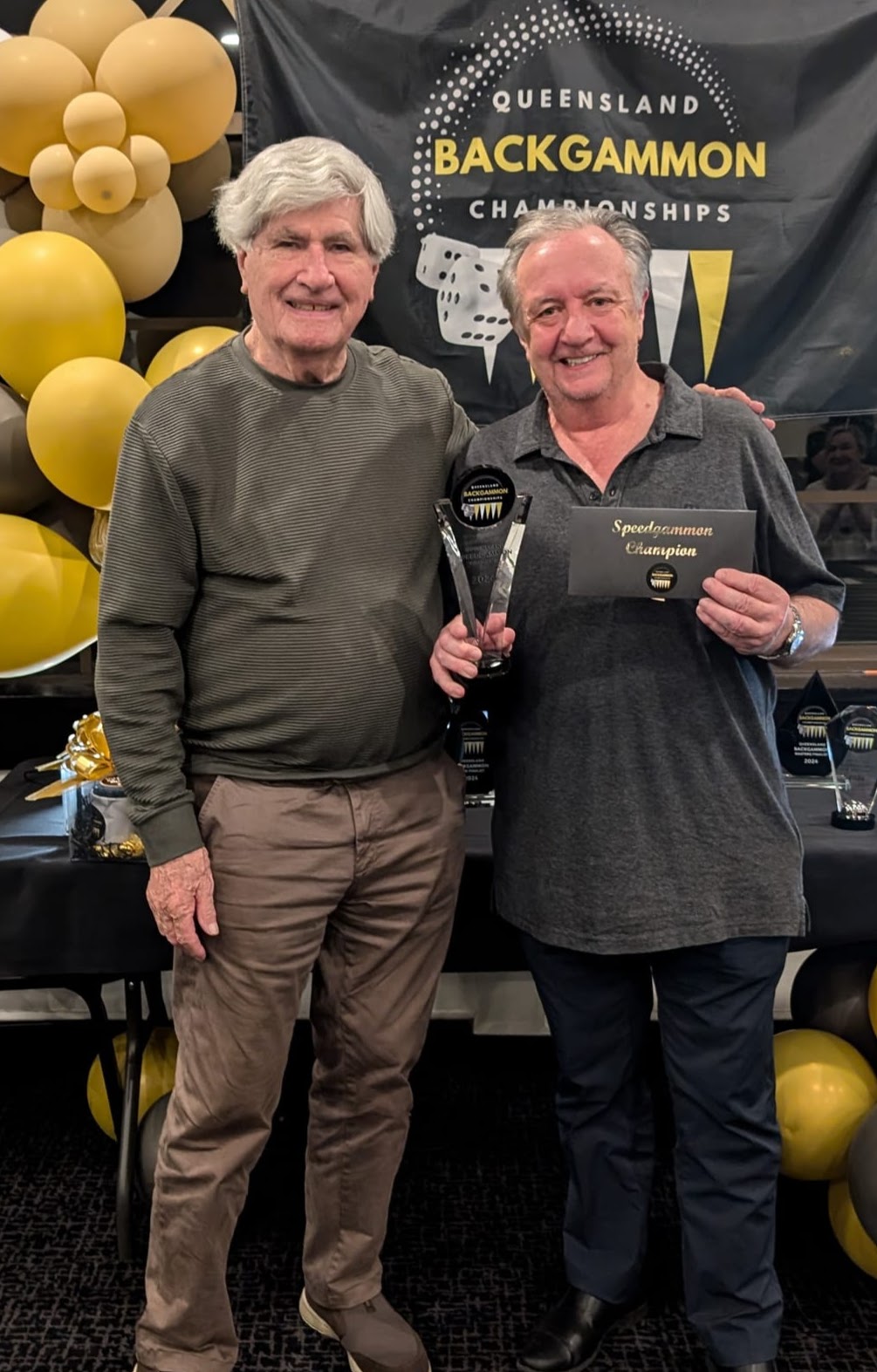 Two men, one of them holding a trophy he has just received